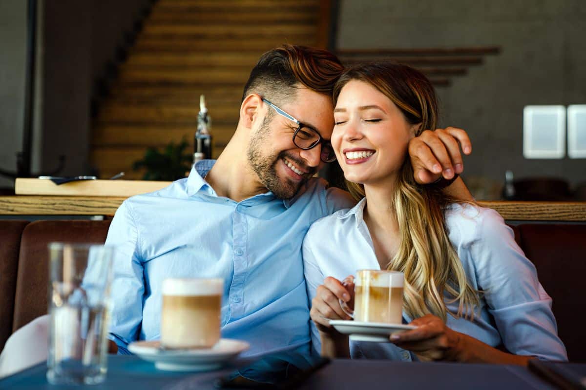 Un couple heureux partage un moment complice dans un café.