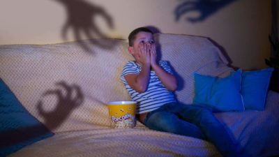 Un enfant terrifié regarde un film
