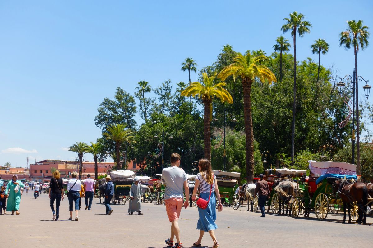 Touristes marchant sur une place à Marrakech