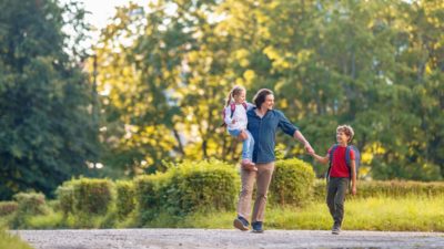 Un père marchant avec ses deux enfants souriants