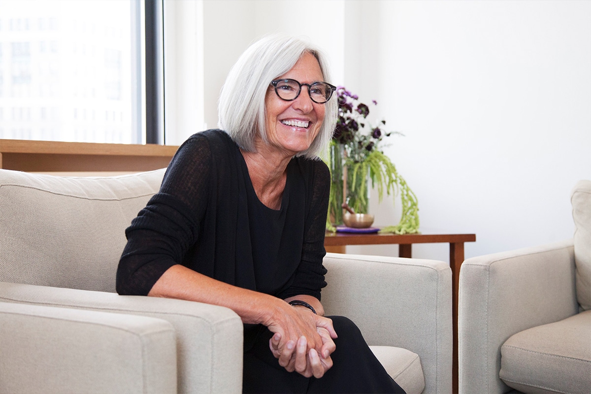 Portrait d'une femme senior souriante, assise dans un cadre élégant