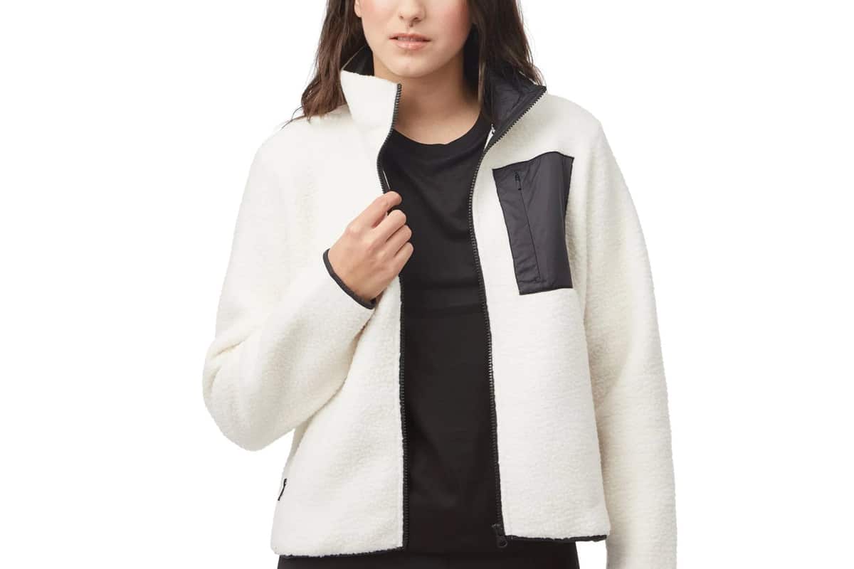 Femme portant une veste polaire blanche Tentree avec une poche contrastante noire