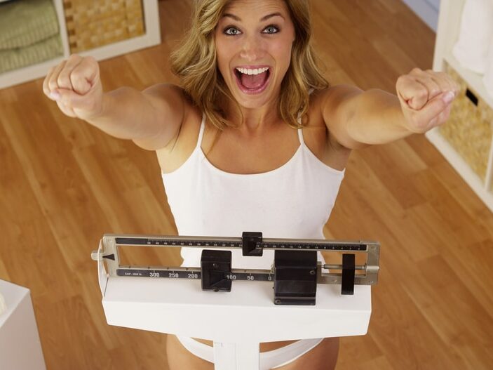 Femme qui se pése sur une balance