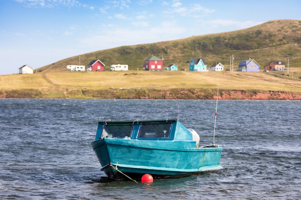 Petit bateau bleu amarré dans les eaux bleues des Îles de la Madeleine