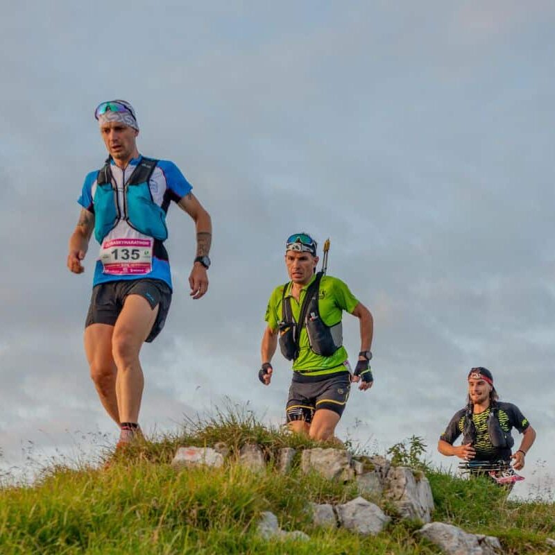 Trois coureurs participent à une course en montagne.